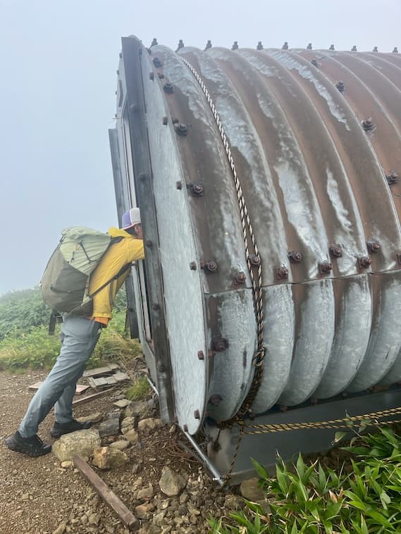 ドラム缶シェルターを覗き込む様子